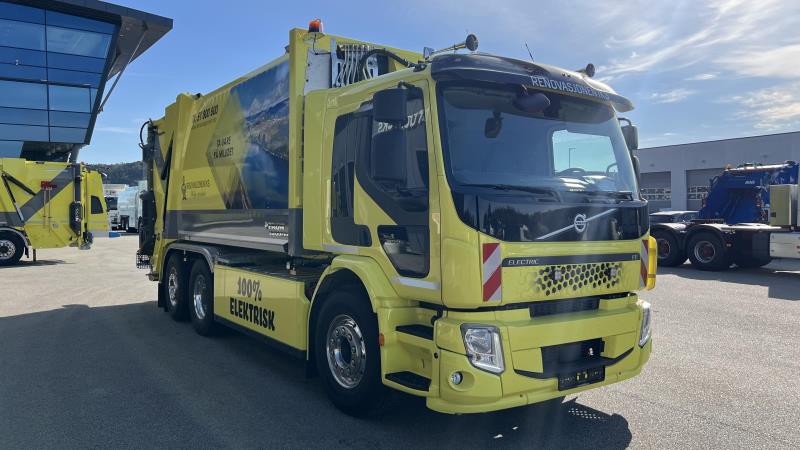 Foto av gul søppelbil