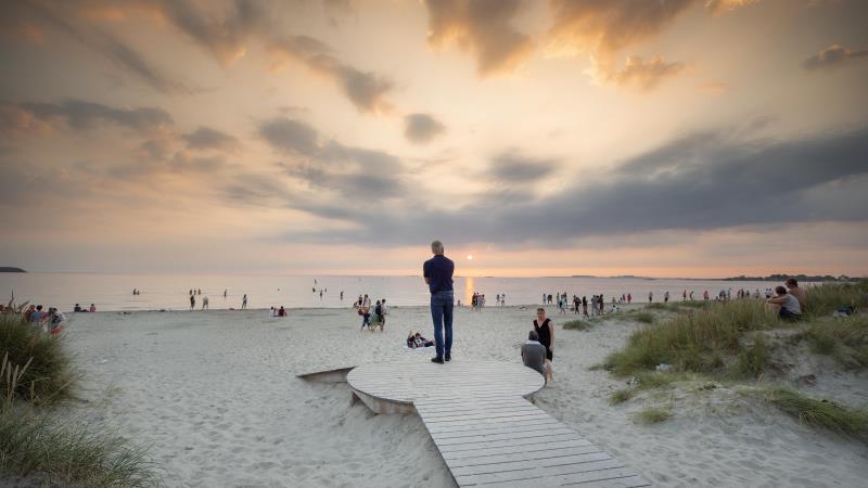 Solnedgang og mennesker på Solastranden en sommerdag.